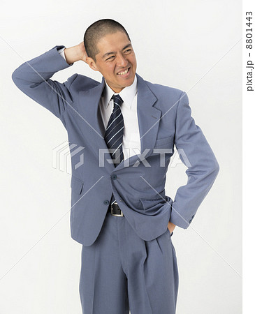 頭をかくスーツ姿の男性の写真素材