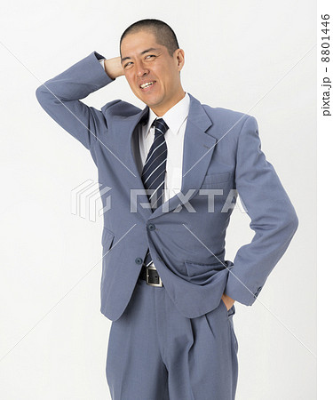 頭をかくスーツ姿の男性の写真素材