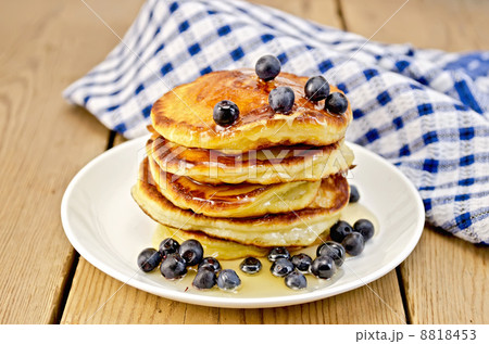 Flapjacks with blueberries and a napkin on the board 8818453