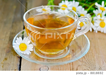 Herbal chamomile tea in a glass cup on a board Herbal chamomile tea in a glass cup on a board 8818692