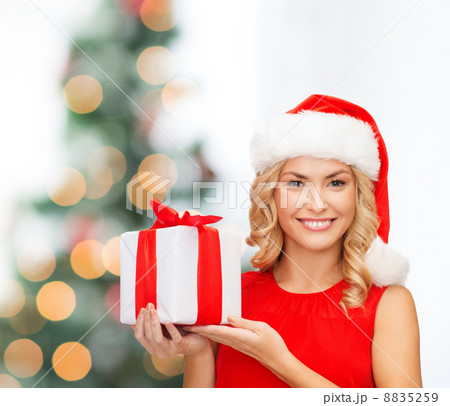 smiling woman in santa helper hat with gift box 8835259