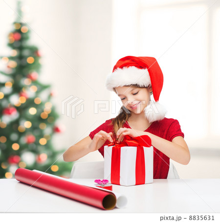 smiling girl in santa helper hat with gift box smiling girl in santa helper hat with gift box 8835631