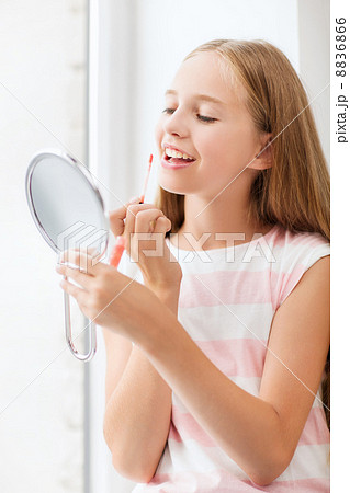 teenage girl with lip gloss and mirror 8836866