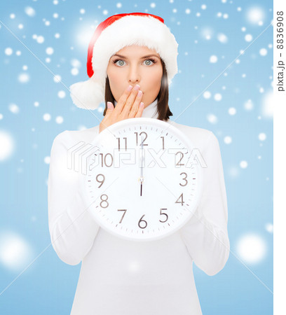 woman in santa helper hat with clock showing 12 woman in santa helper hat with clock showing 12 8836908
