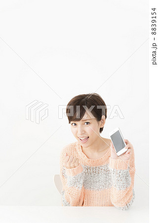 スマホでネット検索するカジュアルな装いの女性 8839154