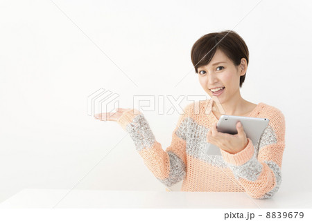 タブレットでネット検索するカジュアルな装いの女性 8839679