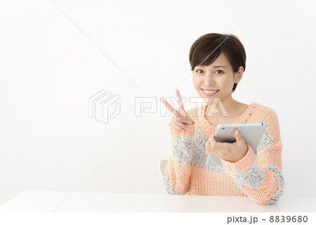 タブレットでネット検索するカジュアルな装いの女性 8839680