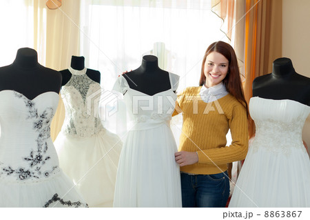 Smiling woman chooses wedding dress 8863867
