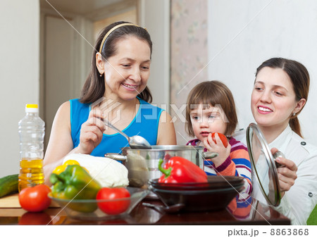 Mature woman and her daughter with baby cook lunch 8863868