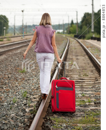 woman with luggage walking on rail 8864853
