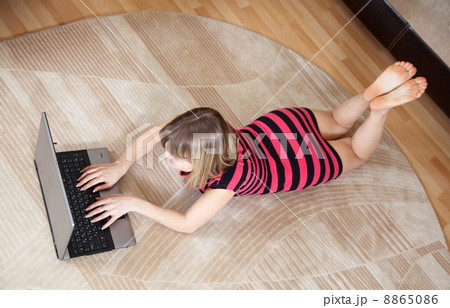 girl lying on floor and using laptop 8865086