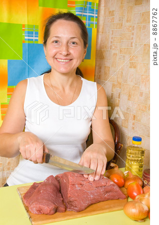 Mature woman is cooking beef Mature woman is cooking beef 8867762