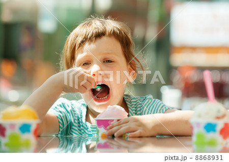 3 years baby girl eating ice cream at outdoor cafe 3 years baby girl eating ice cream at outdoor cafe 8868931