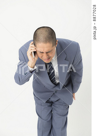 電話で謝る男性の写真素材