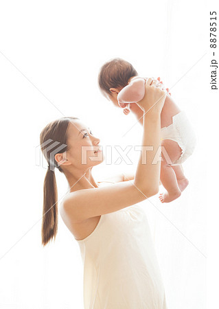 生後3ヶ月の赤ちゃんを高い高いするママの写真素材