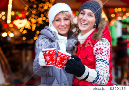Friends drinking spiced wine on Christmas market 8890136