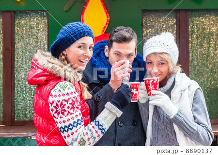 Friends drinking mulled wine on Christmas marked 8890137