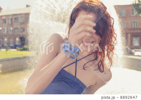 redhead women near fountain summertime sunlit redhead women near fountain summertime sunlit 8892647