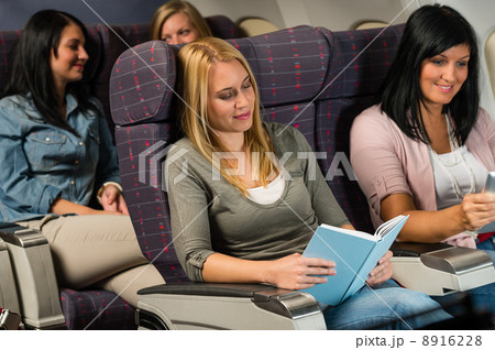 Young woman passenger read book airplane flight 8916228