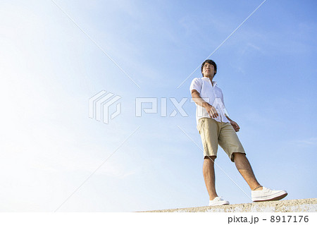 防波堤の上を歩く男性の写真素材