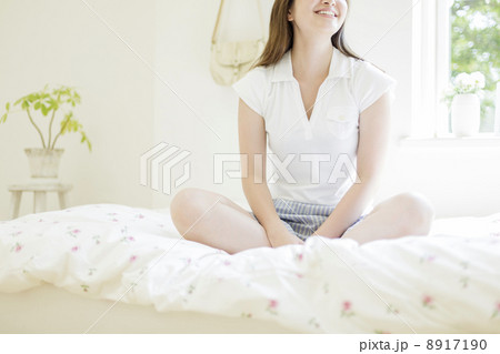 ベッドの上に座る女性の写真素材 8917190 Pixta