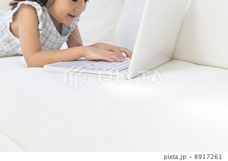 ソファの上でノートパソコンを操作する女の子 8917261