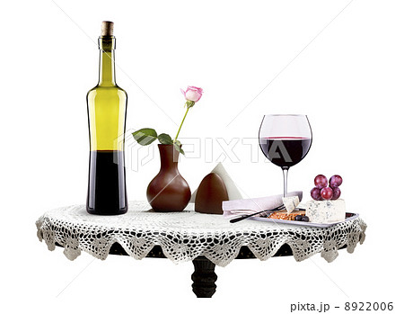 bottle, wine glass with flower and food on a table 8922006