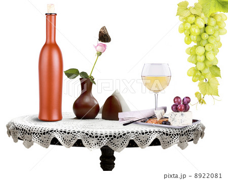 bottle, wine glass with flower and food on a table 8922081