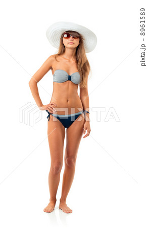 Portrait of a beautiful young woman posing in bikini, hat and su 8961589