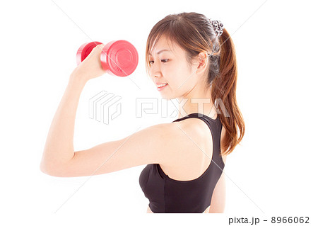 ダンベルで腕の筋肉を鍛える爽やかな日本の女性の写真素材