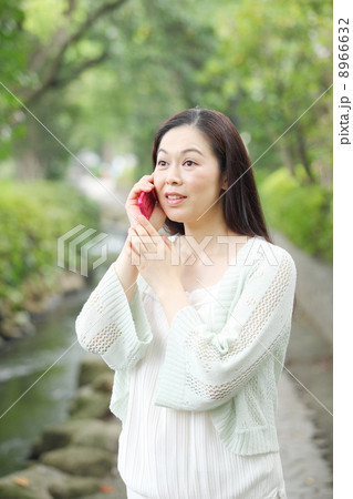 電話を使用する中年女性 8966632