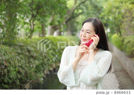電話を使用する中年女性 8966633
