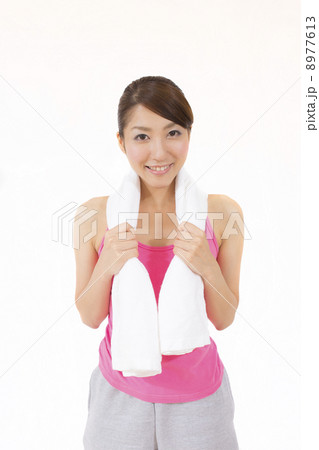 トレーニング中にタオルで汗を拭く若い女性 8977613