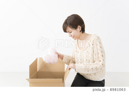 ハートを手にする女性とダンボール箱 8981063