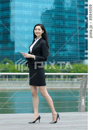 Pretty office lady using mobile along waterway Pretty office lady using mobile along waterway 8984009