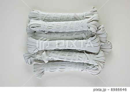 Sewing white rubber on a reel on white background Sewing white rubber on a reel on white background 8986646