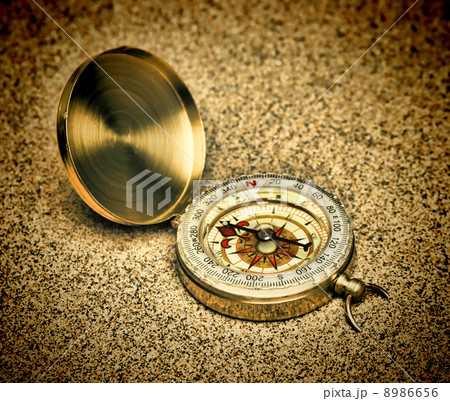 Old compass on a sandy beach Old compass on a sandy beach 8986656