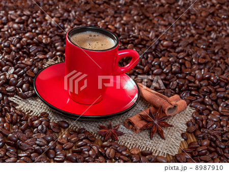 Coffee in a red cup with cinnamon and anise stars. Coffee in a red cup with cinnamon and anise stars. 8987910