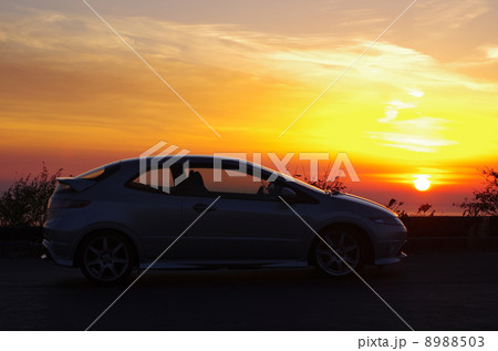 西伊豆に沈む太陽とスポーツカー 8988503