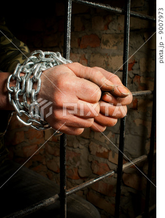 Man with hands tied up with chains 9007973