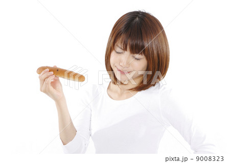 ダイエット中に誘惑と戦う若い女性 9008323