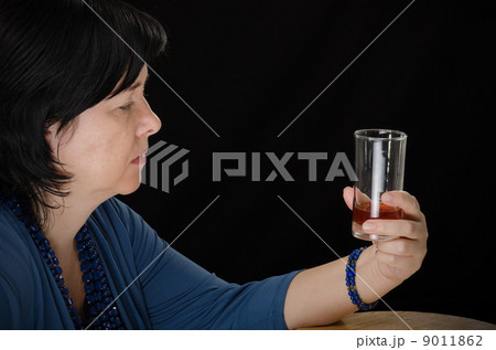 Alcoholic woman with glass of brandy 9011862