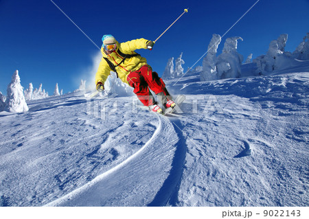 Skier skiing downhill in high mountains 9022143