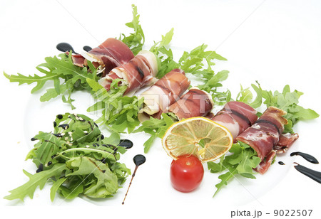 rolls of meat and greens on a white background in the restaurant 9022507