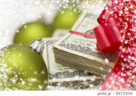 Stack of Hundred Dollar Bills with Bow Near Christmas Ornaments Stack of Hundred Dollar Bills with Bow Near Christmas Ornaments 9025956