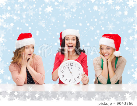 women in santa helper hats with clock showing 12 women in santa helper hats with clock showing 12 9043266