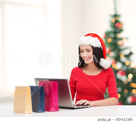 woman with shopping bags and laptop computer 9043286