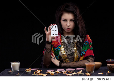 Attractive young fortune teller holdin card Attractive young fortune teller holdin card 9049381