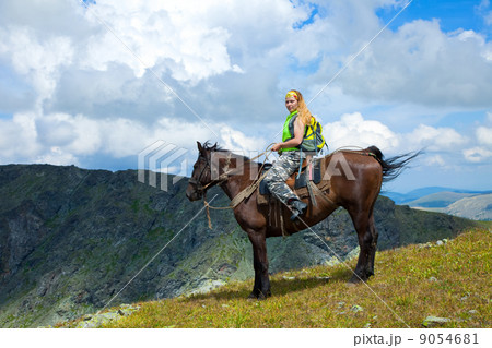 Female rider on horseback at mountains Female rider on horseback at mountains 9054681