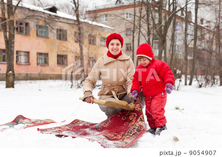 mother with child cleans rug with snow 9054907